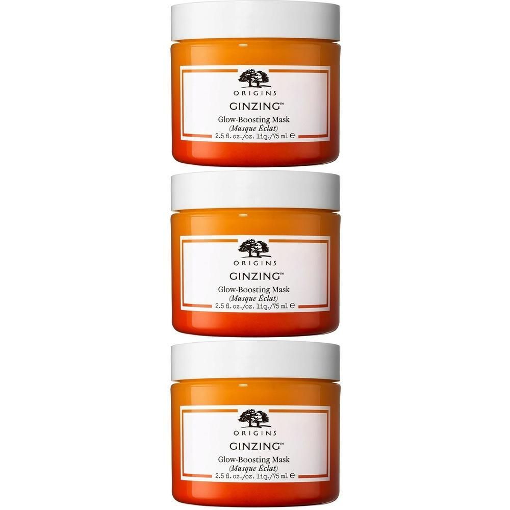 Drie potten Origins GinZing Glow-Boosting Mask met witte deksel en oranje basis.