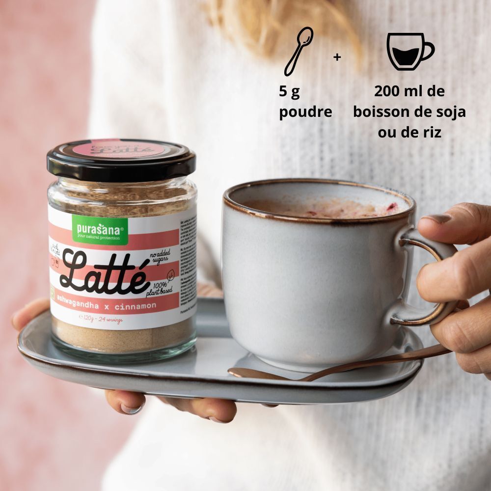 Pot de Purasana® Latté Ashwagandha x Cannelle Bio en poudre à côté d'une tasse.