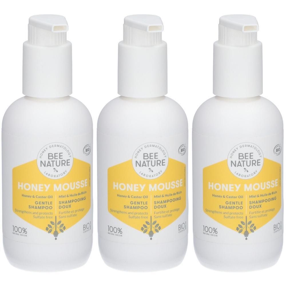 Drie witte pompflesjes met geel etiket voor Honey Mousse shampoo.