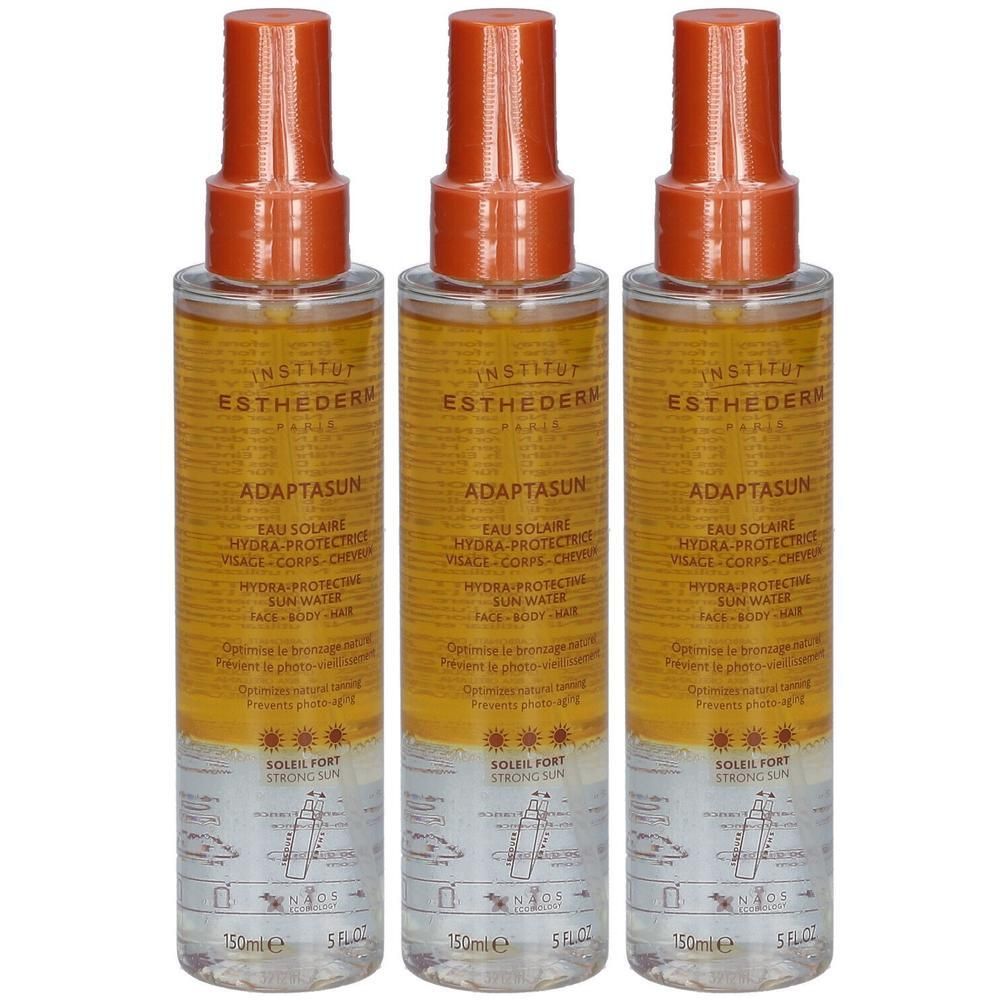 Drie flessen Institut Esthederm Adaptasun zonnebrandspray met oranje spuitkoppen. Heldere vloeistof met geel etiket.