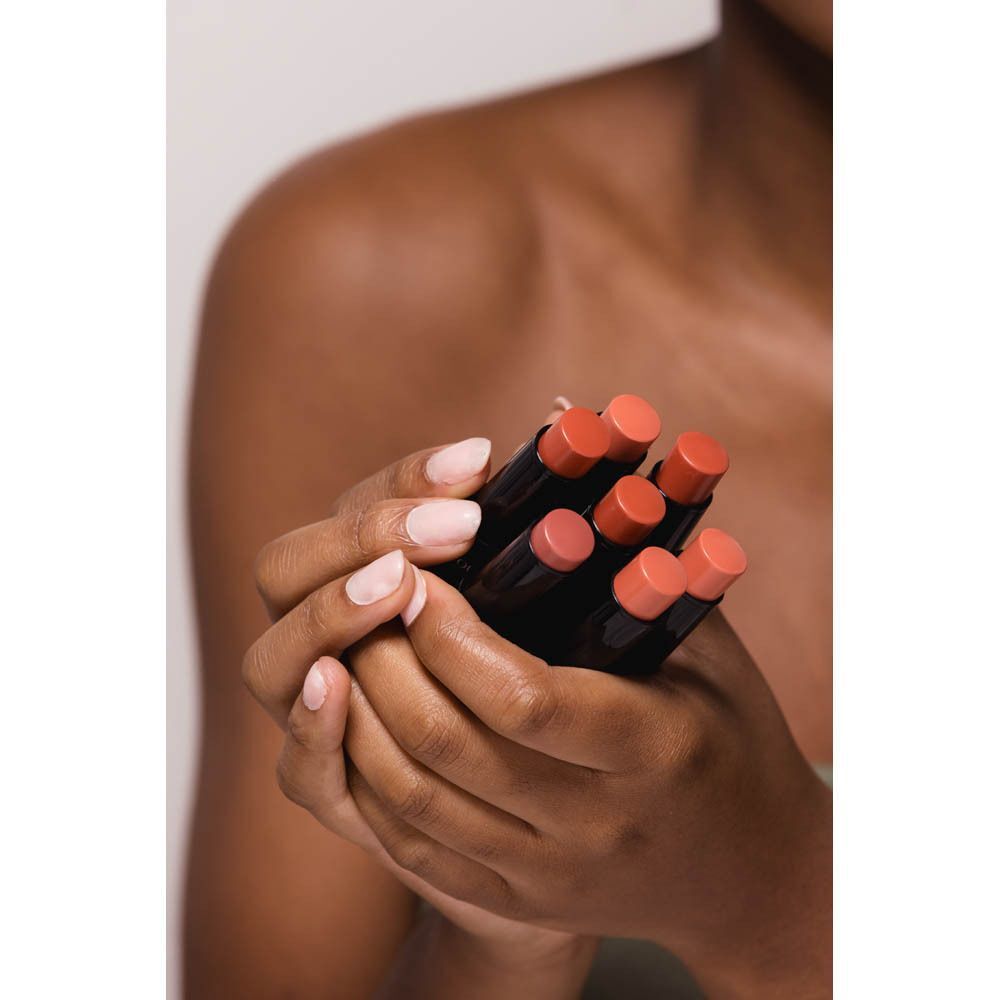 Handen vasthouden meerdere COULEURS DE NOIR Creamy Blush Sticks in roze tinten.