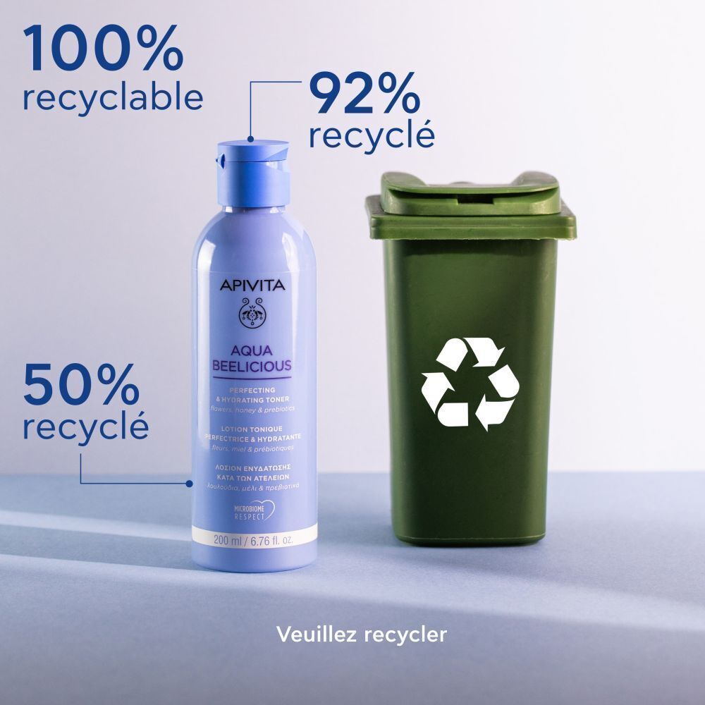 Apivita Aqua Beelicious Lotion Tonique Perfectrice & Hydratante à côté d'une poubelle verte symbolisant le recyclage.