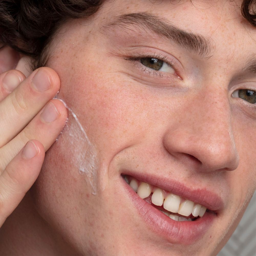 Un homme applique la SVR Hydraliane Crème Légère sur son visage.