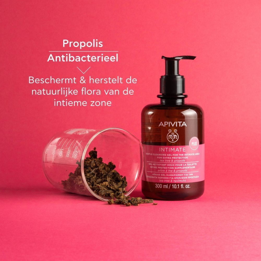 Apivita Intimate reinigingsgel, vastgehouden door een hand voor een achtergrond van benen.