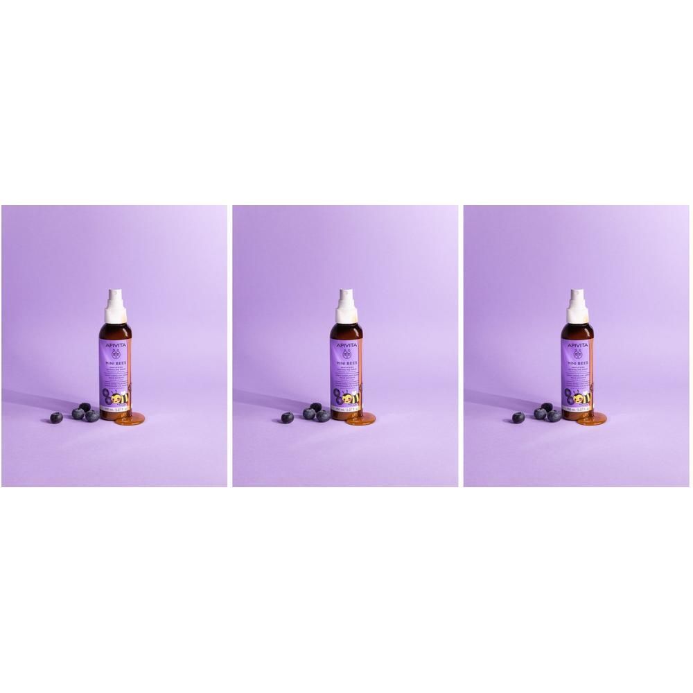 Drie flessen Apivita Mini Bees ontwarrende spray op paarse achtergrond.