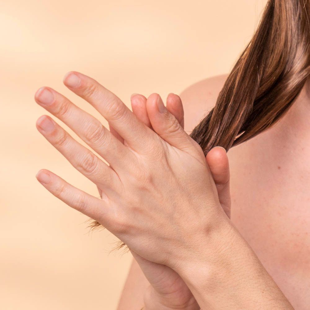 Een hand draait door een lok haar.