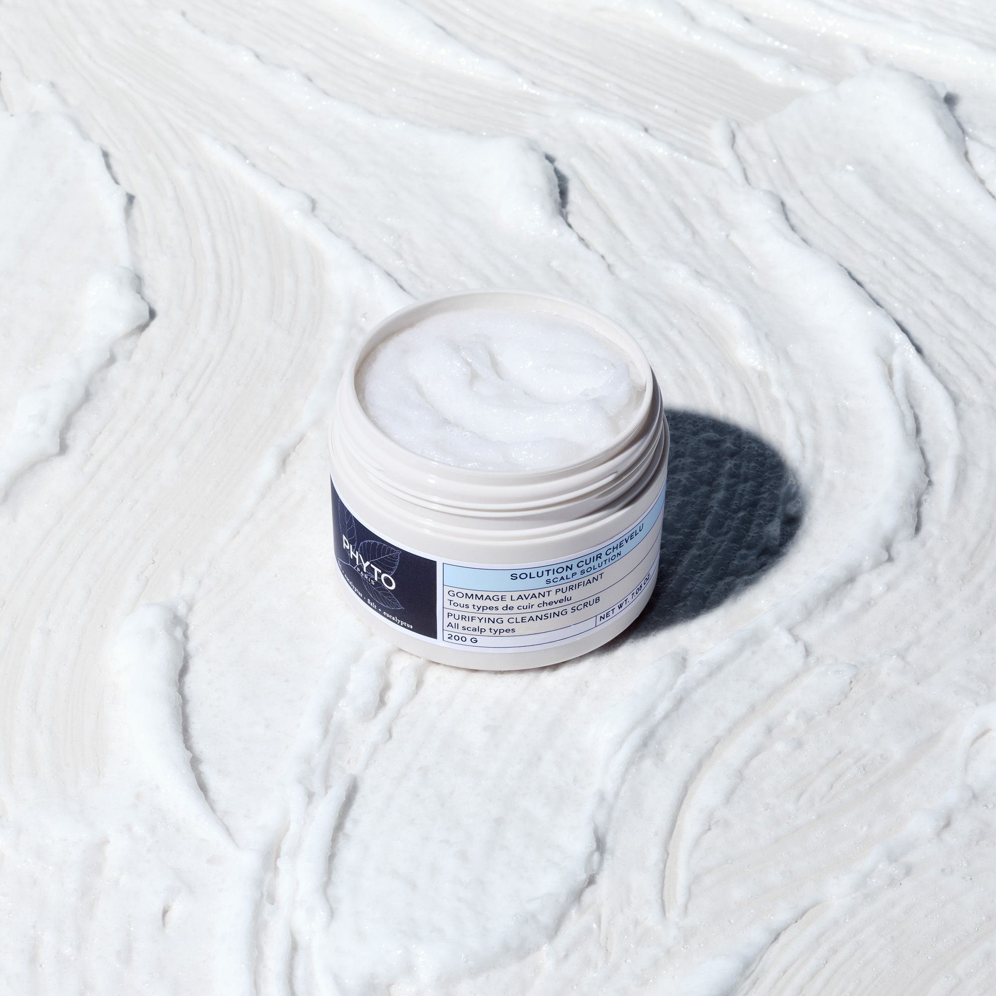 Een geopende pot Phyto Solution Cuir Chevelu Gommage Lavant Purifiant op witte ondergrond.