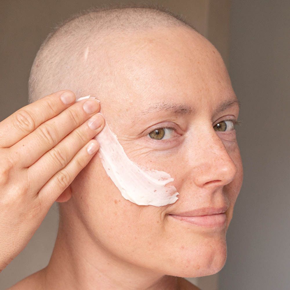 Une femme applique le Masque Visage Ultra-Réconfortant sur son visage.