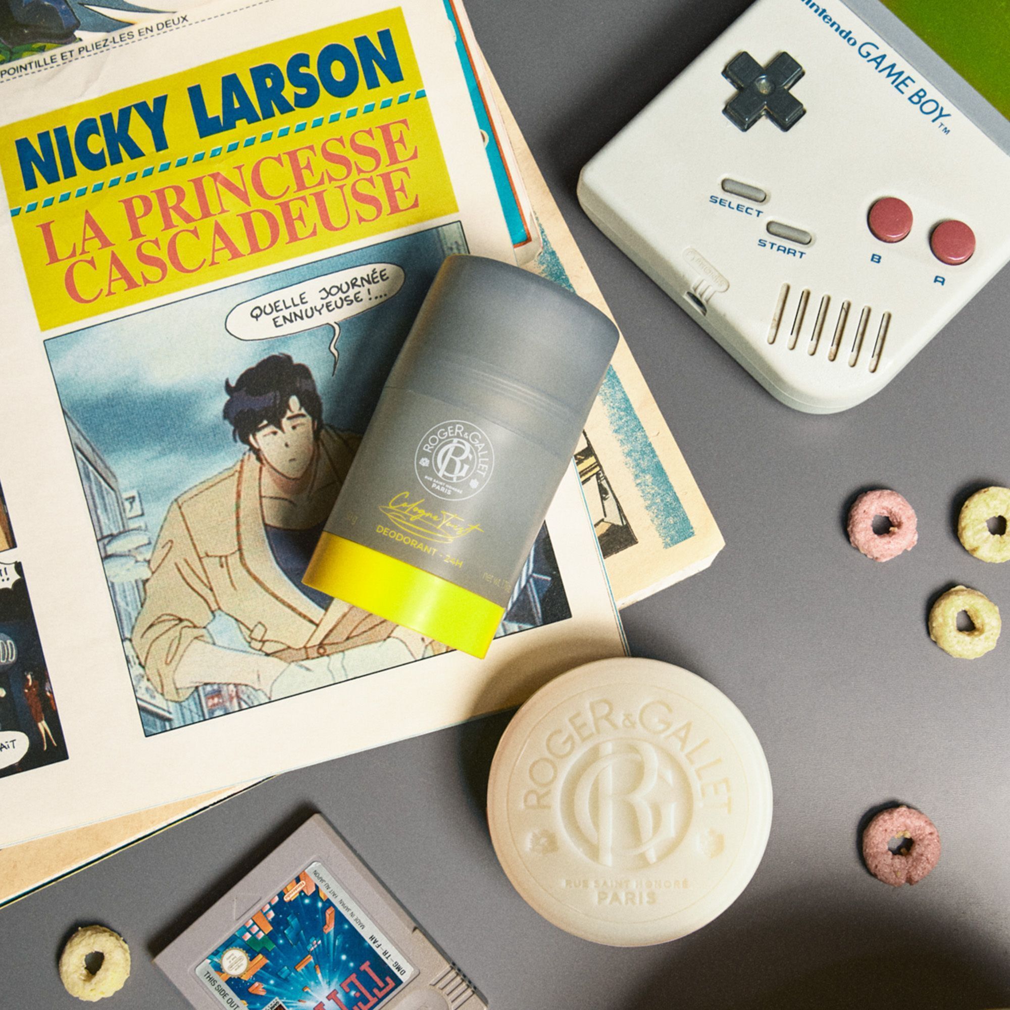 Roger & Gallet zeep en deodorant naast stripboek en Game Boy.