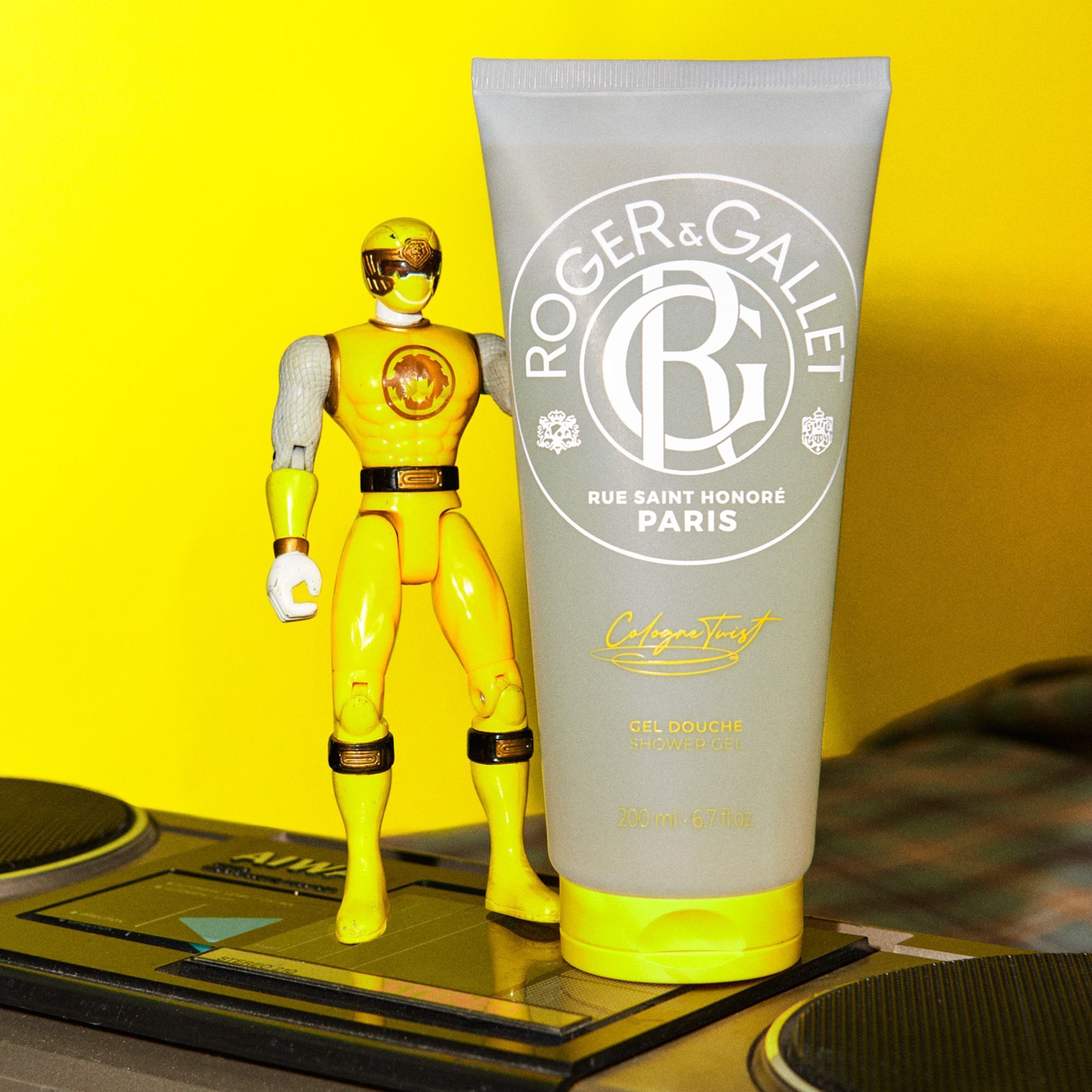 Douchegel tube van Roger & Gallet "Cologne Twist" naast een gele figuur.