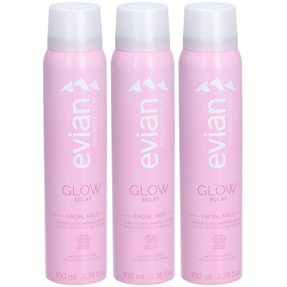 Drie roze spuitbussen Evian Brumisateur Éclat Glow Facial Mist met witte dop.