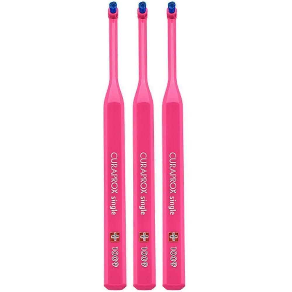 Drie roze Curaprox Single tandenborstels met blauwe borstelkoppen en opschrift 'CURAPROX single 1009'.