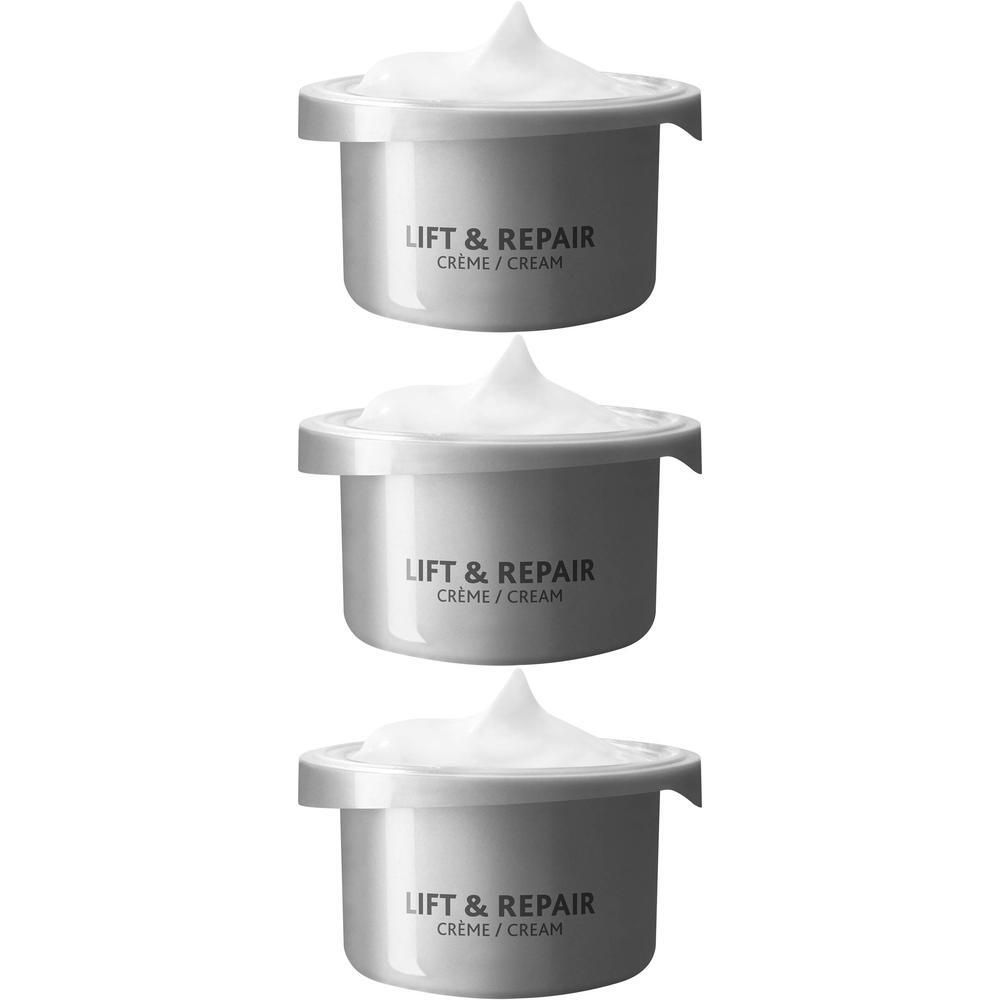 Drie zilverkleurige potjes met witte crème, met opschrift 'LIFT & REPAIR CRÈME / CREAM'.