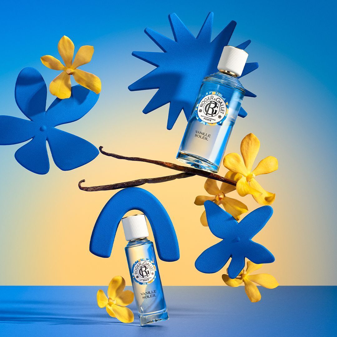 Deux flacons Roger & Gallet Eau Parfumée Vanille Soleil entourés de formes bleues et de fleurs jaunes.