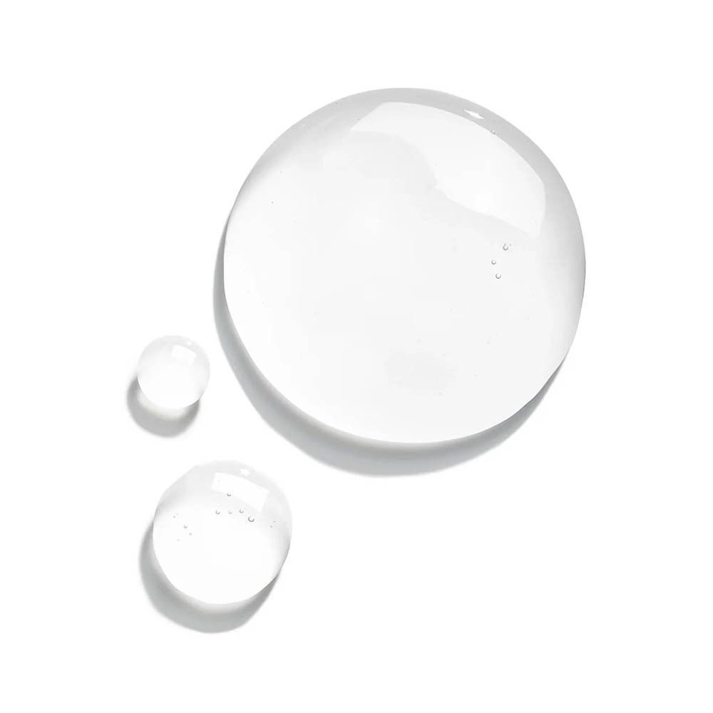 Gouttes d'un liquide clair posées sur une surface blanche.