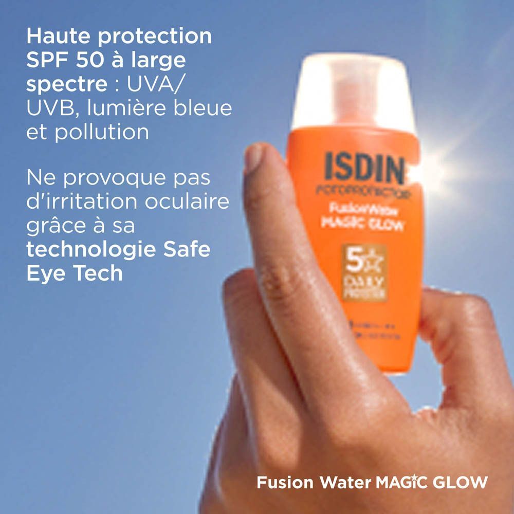 Une main tenant une protection solaire ISDIN Fusion Water Magic Glow SPF50 devant un ciel bleu.