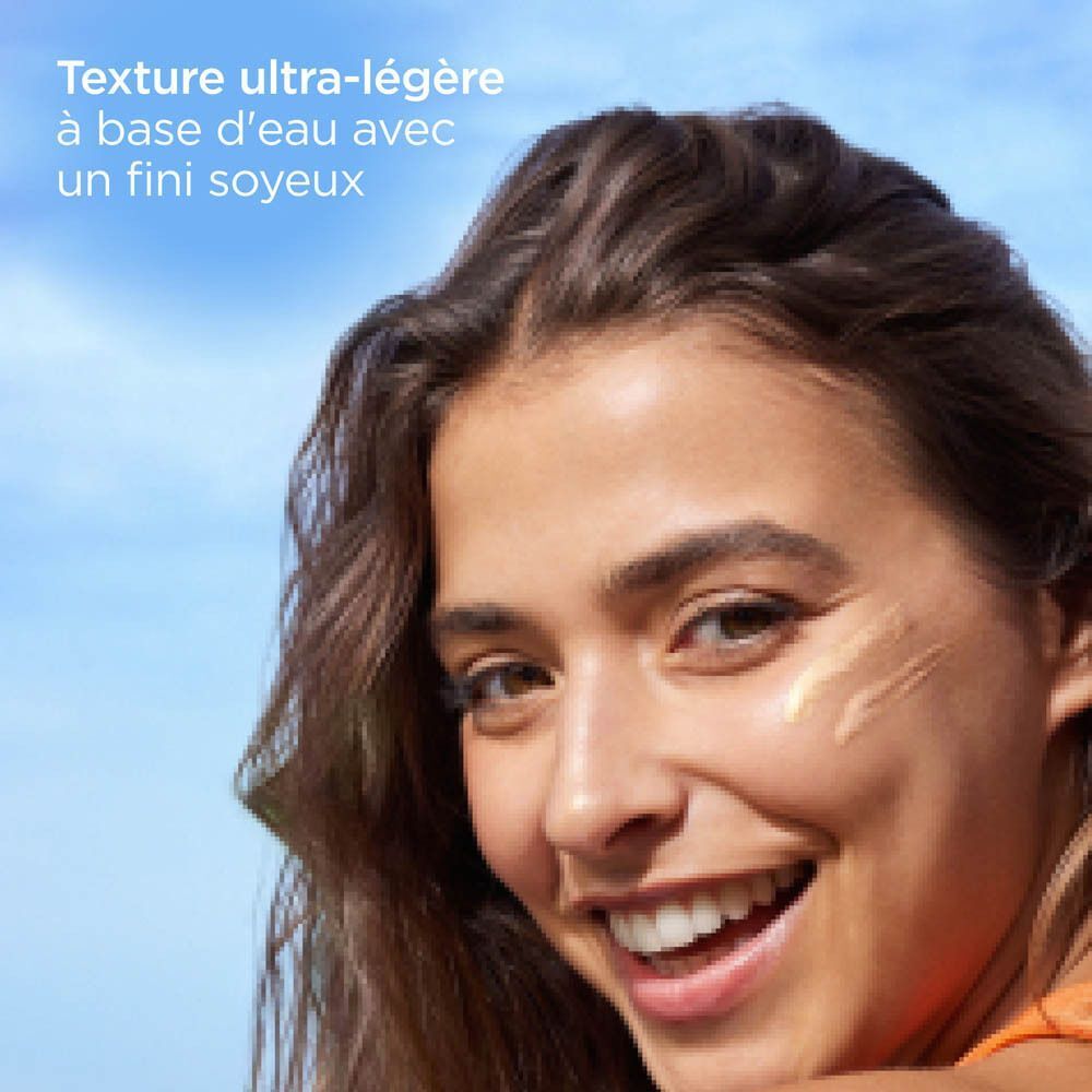 Gros plan d'une femme souriante avec deux traînées d'ISDIN Fusion Water Magic Glow sur la joue.