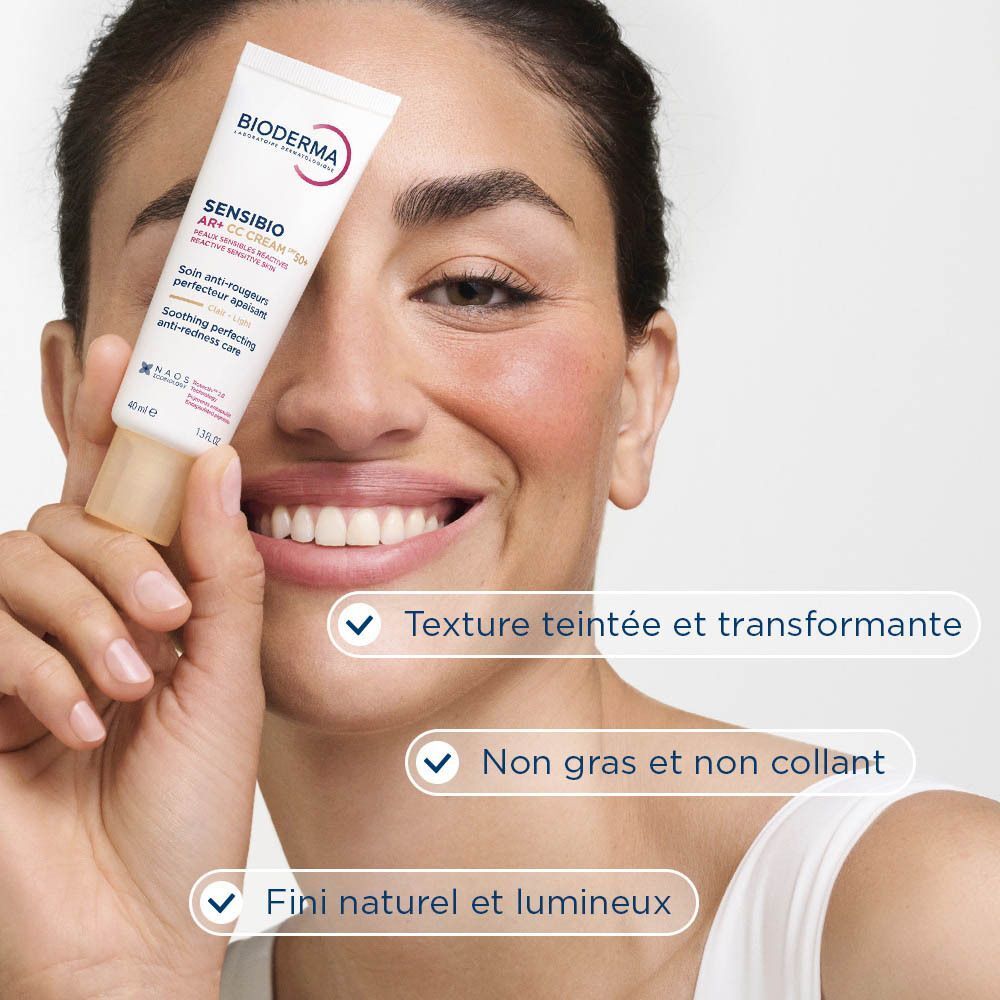 Femme tenant un tube de Bioderma Sensibio AR+ CC Cream SPF50+ Clair.