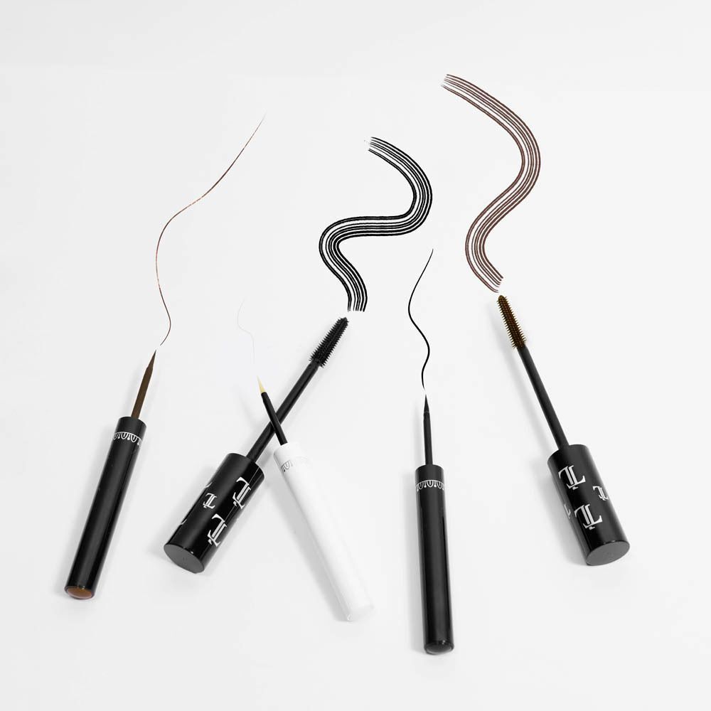 Vier cosmetische applicators met kleurstrepen in bruin, zwart en goud.
