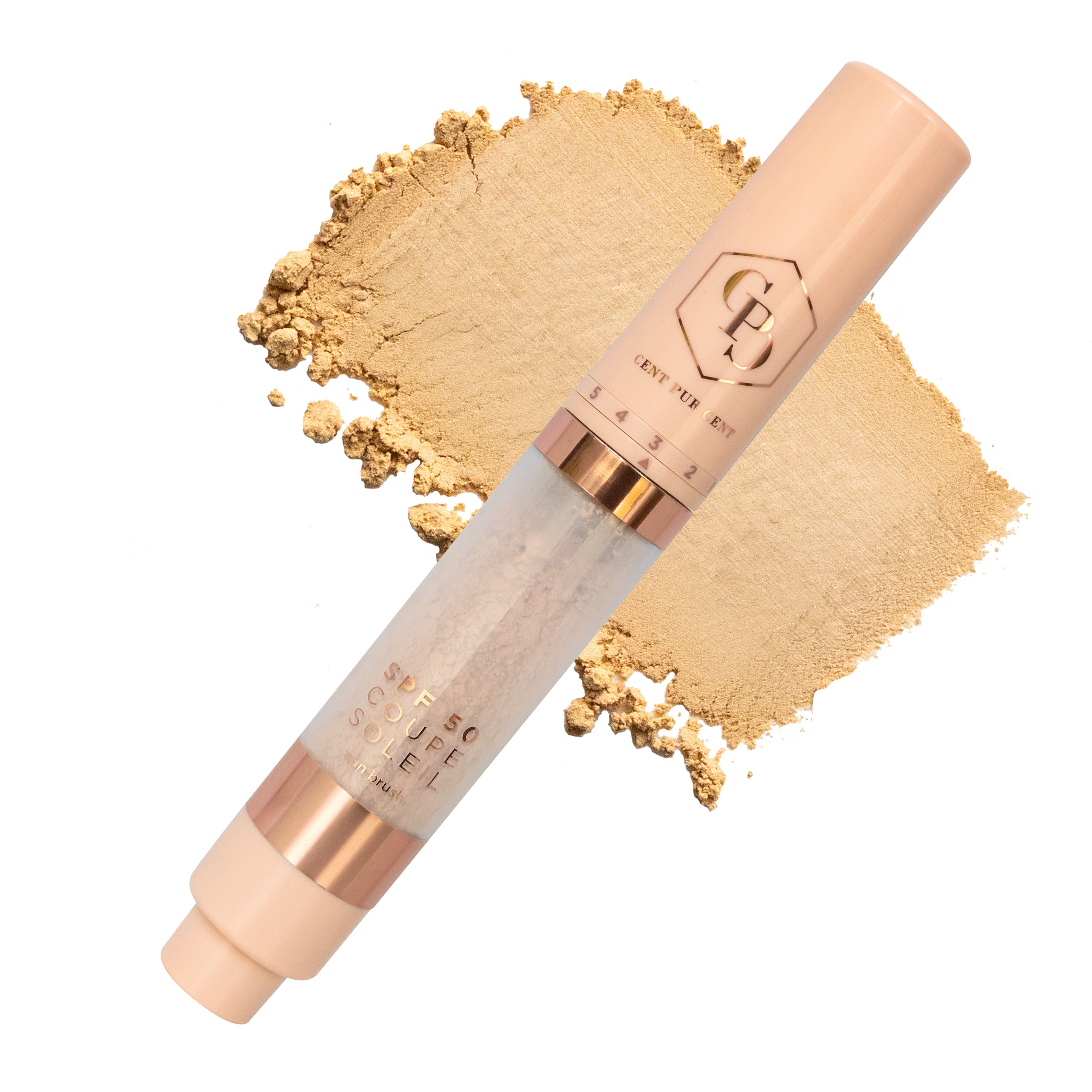 Een Cent Pur Cent Coupe Soleil SPF50 Sunbrush applicator met borstelpunt, naast een veeg goudkleurig poeder.