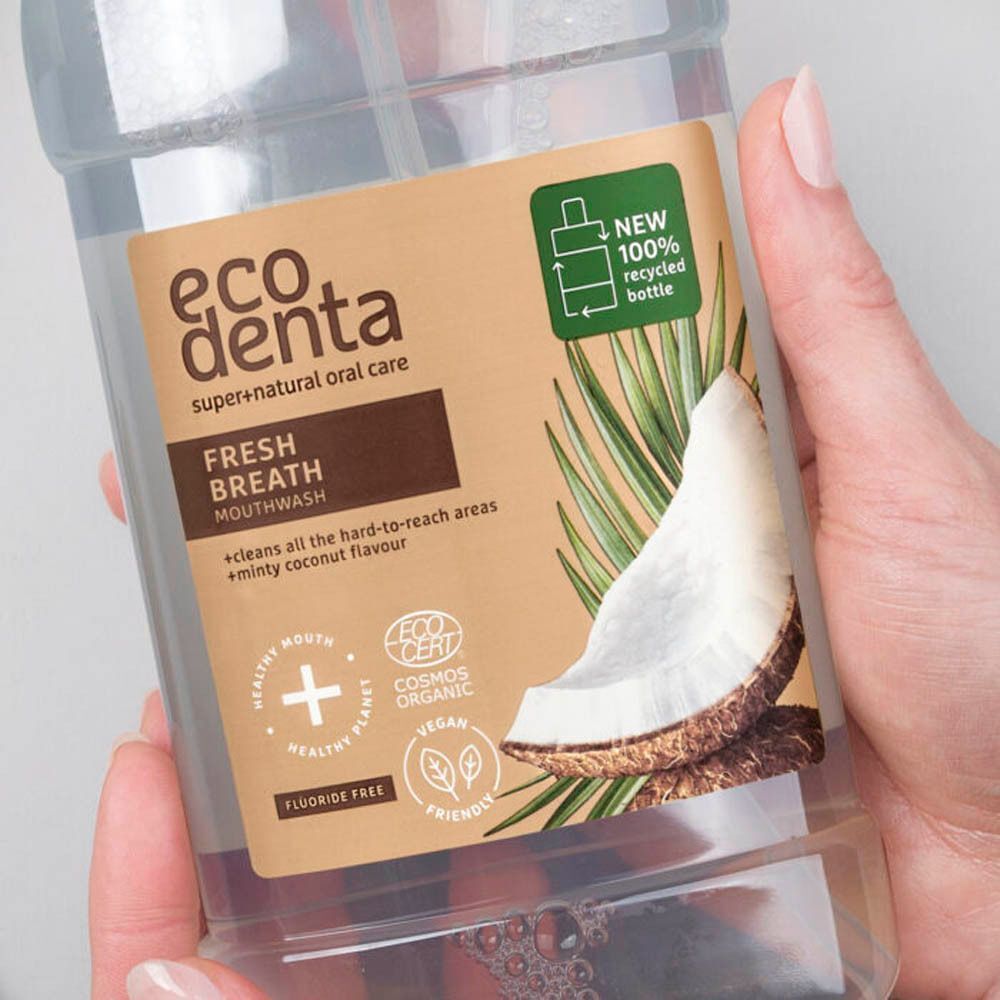 Close-up van een fles Ecodenta mondwater. Etiket toont kokosnoot en palmbladeren. 100% gerecyclede fles.