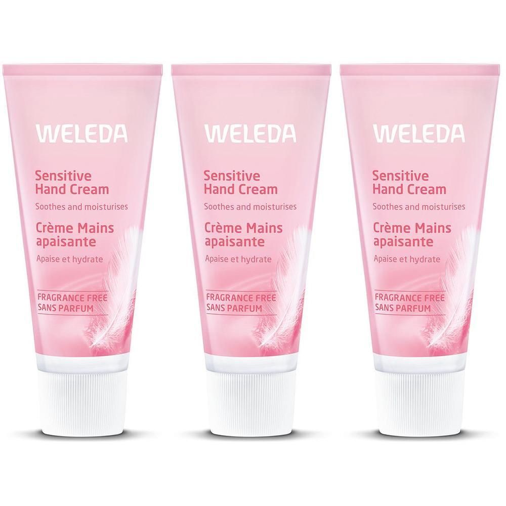 Trois tubes de Crème Mains Apaisante Weleda, bouchon blanc, design rose avec plumes.