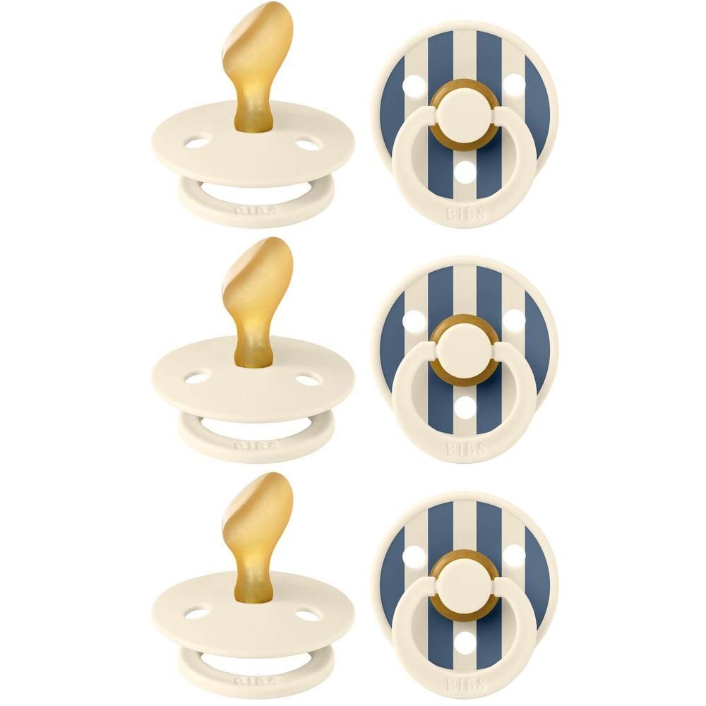 Drie fopspenen met rond schild, twee in crème met gouden speen, één gestreept blauw en wit met gouden knop.