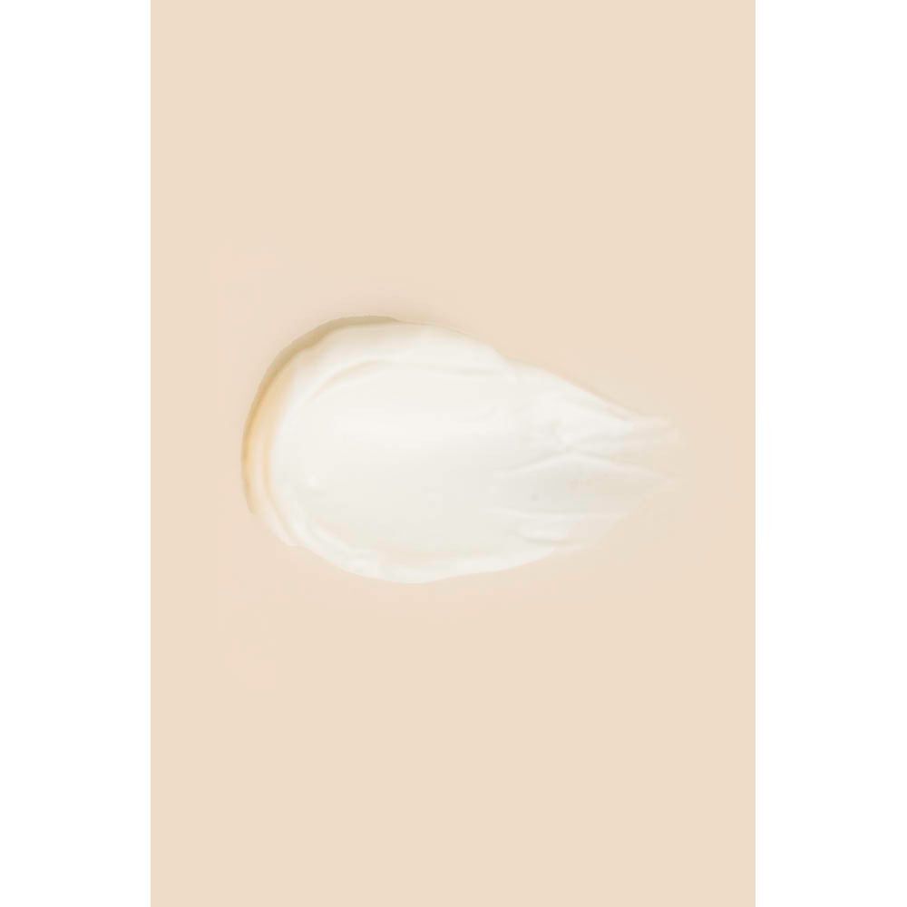 Een klodder witte zonnecrème op een lichte achtergrond.