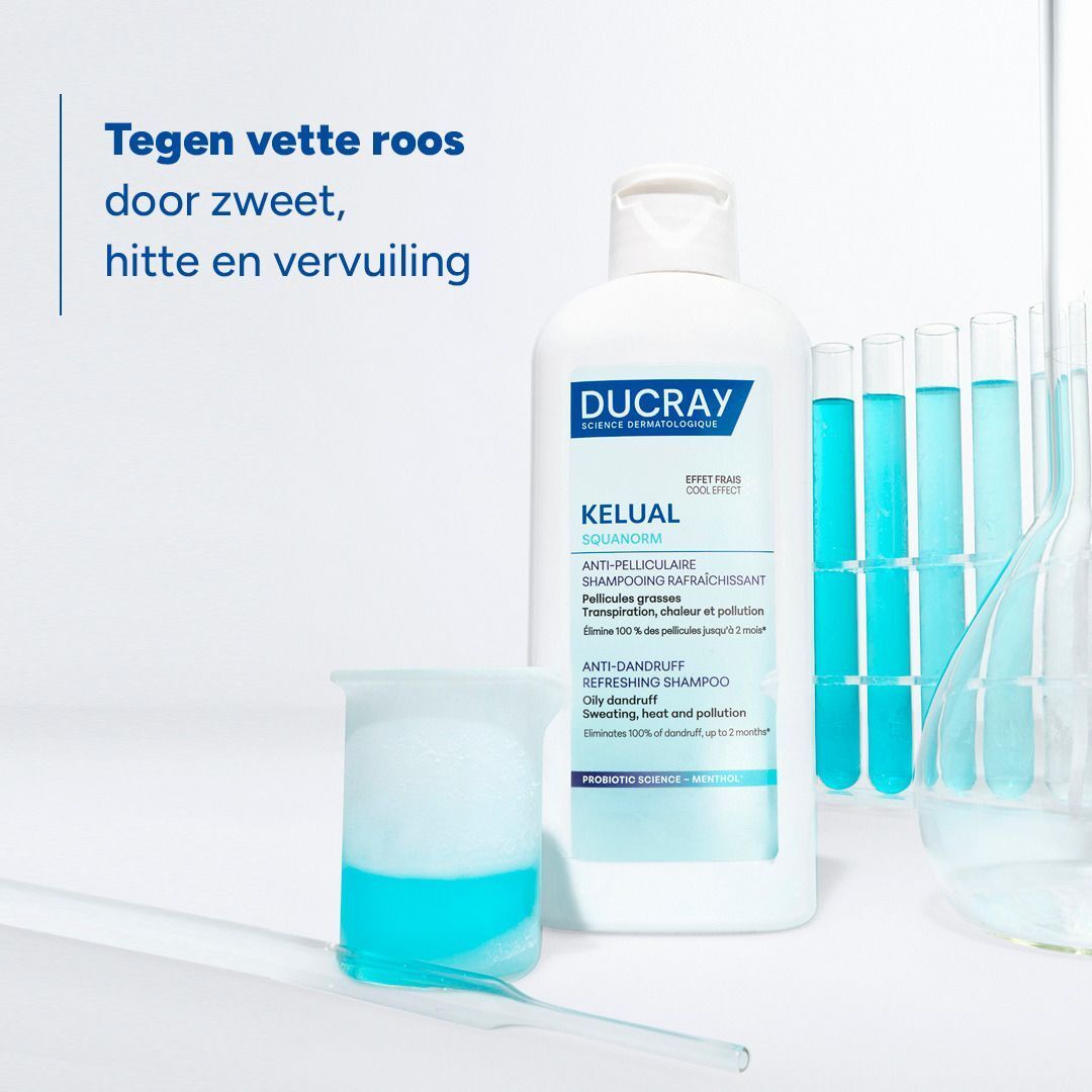 Fles Ducray Kelual Squanorm shampoo naast laboratoriumapparatuur.