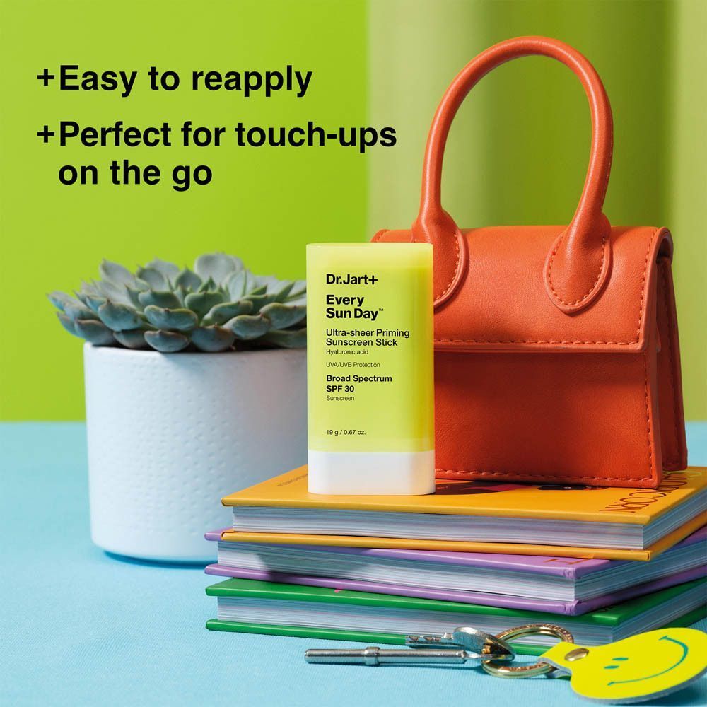 Bâton solaire près d'un sac à main et de livres. Texte : Facile à réappliquer, parfait pour les retouches.