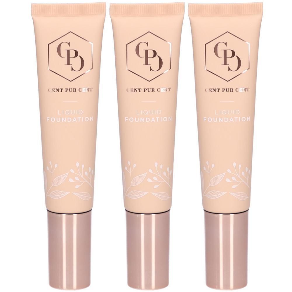 Trois tubes de fond de teint liquide avec motif floral et bouchon doré rose.