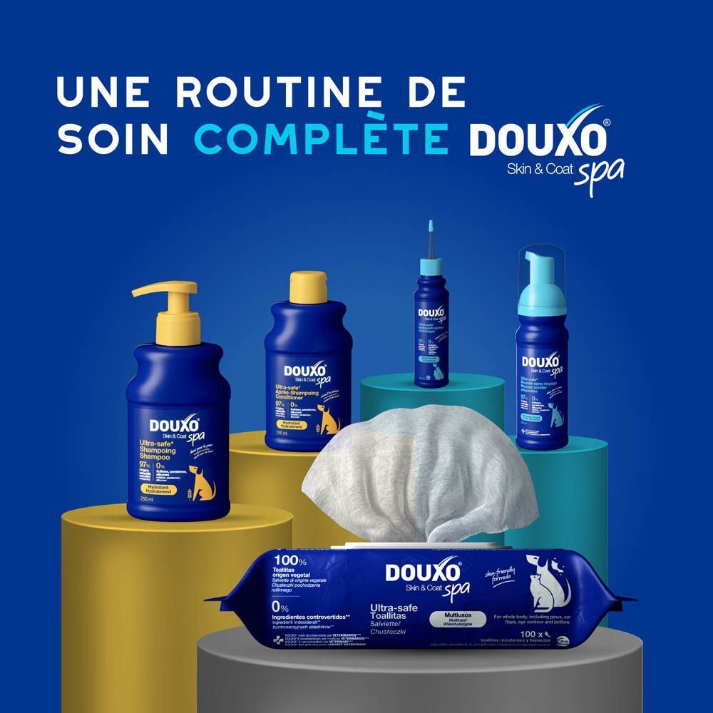 Plusieurs produits DOUXO® : distributeur, flacons, serviette et lingettes.