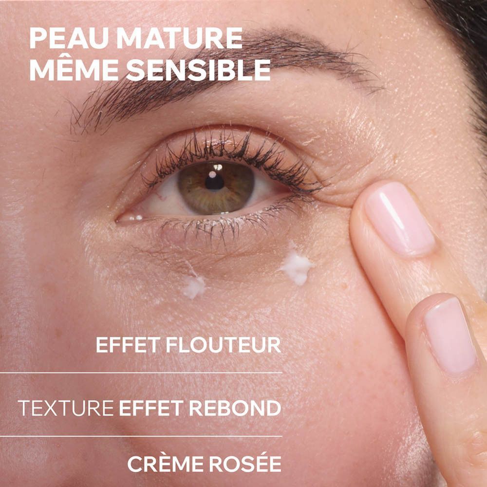Une femme applique le baume regard Uriage Age Absolu pour un effet flouteur.