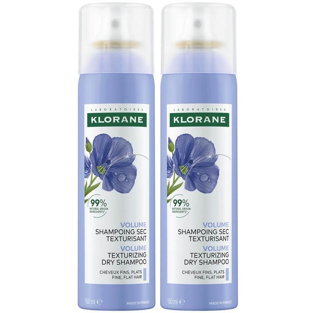Deux Klorane Shampoings Secs Texturisants en aérosols bleus, décorés de fleurs de lin.