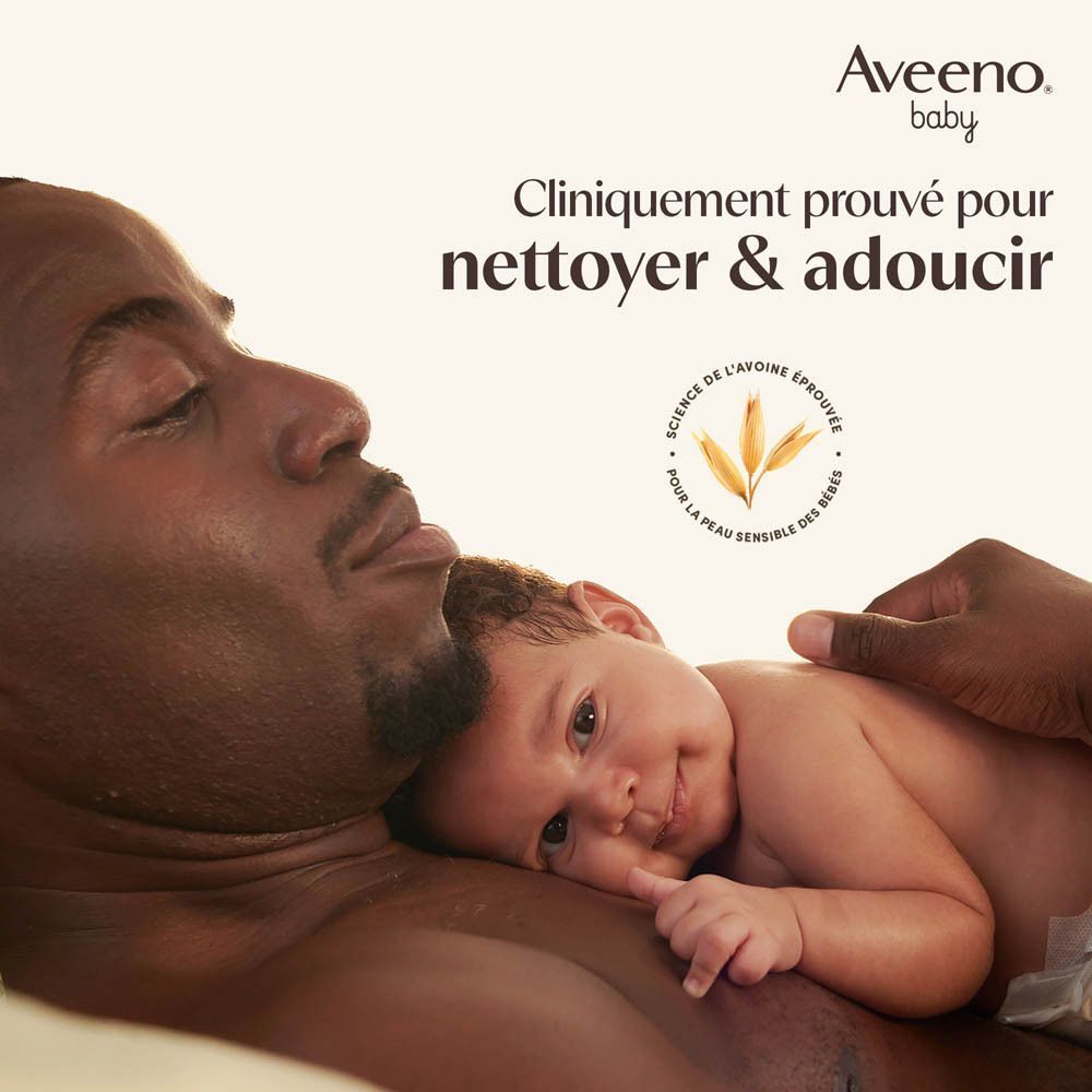 Un homme tient un bébé sur sa poitrine. Logo Aveeno Baby en haut à droite.