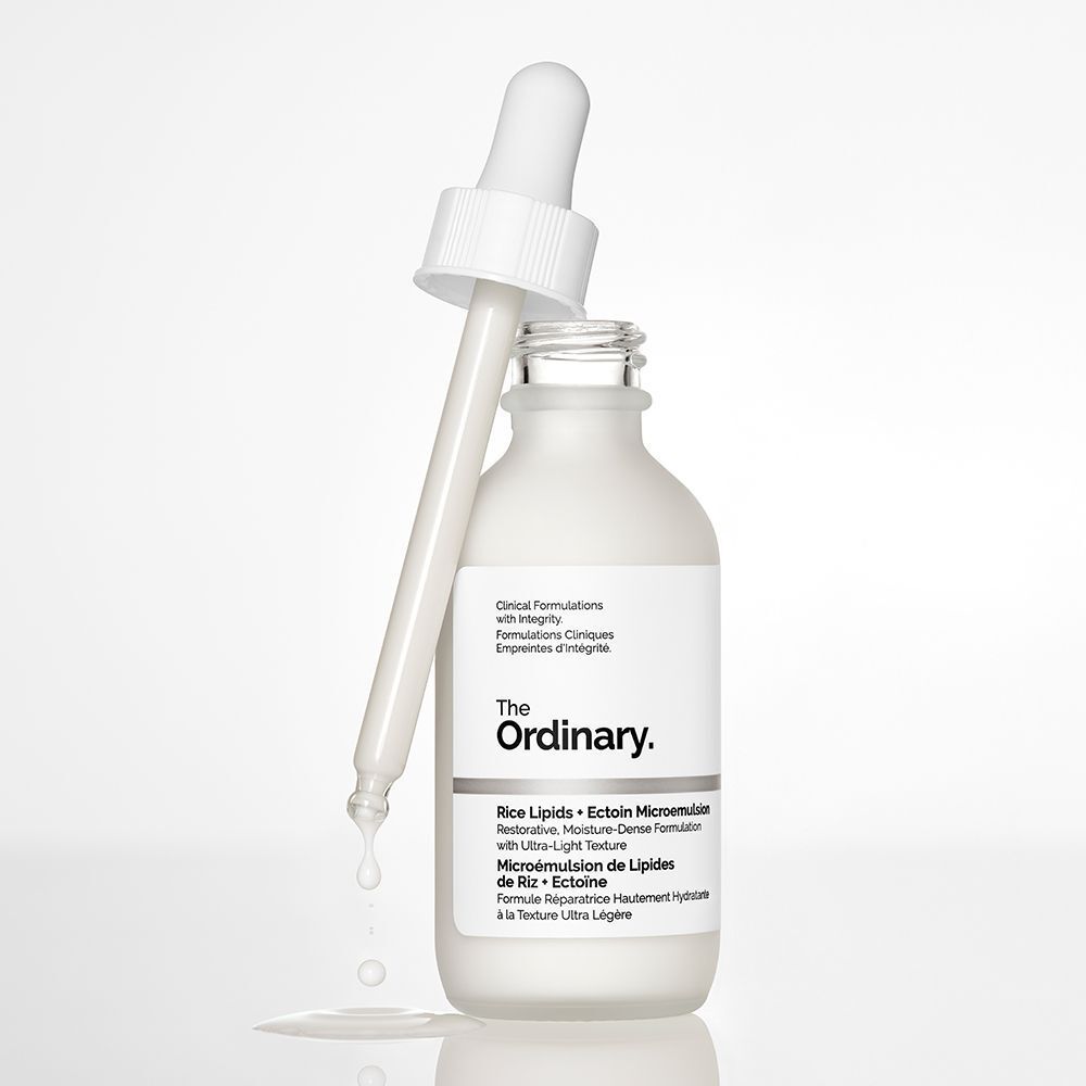 Un flacon The Ordinary Rice Lipids + Ectoin Microemulsion avec pipette et liquide dégoulinant.