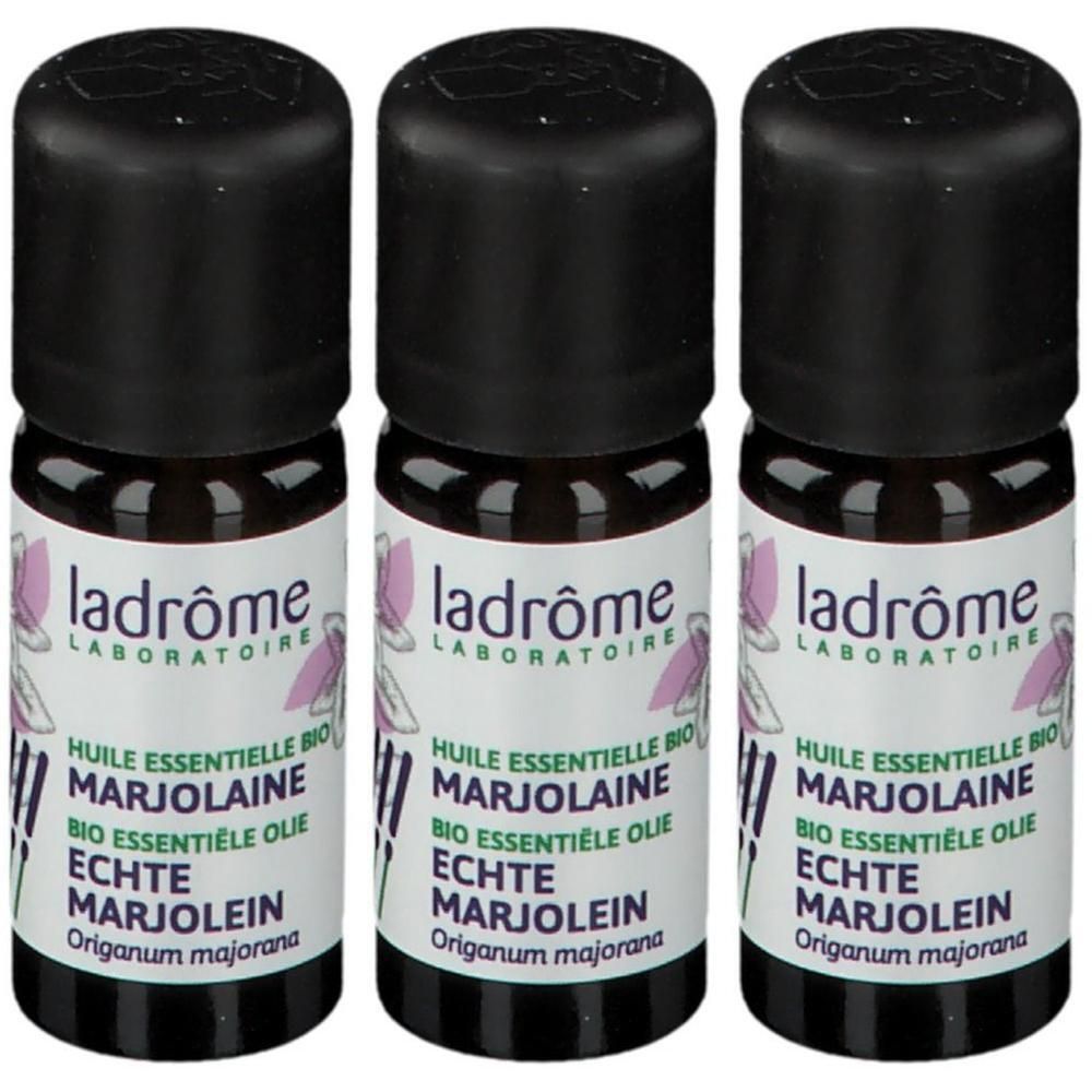 Drie flesjes Ladrôme biologische Marjolein etherische olie. Zwarte doppen, witte etiketten met plantafbeelding.