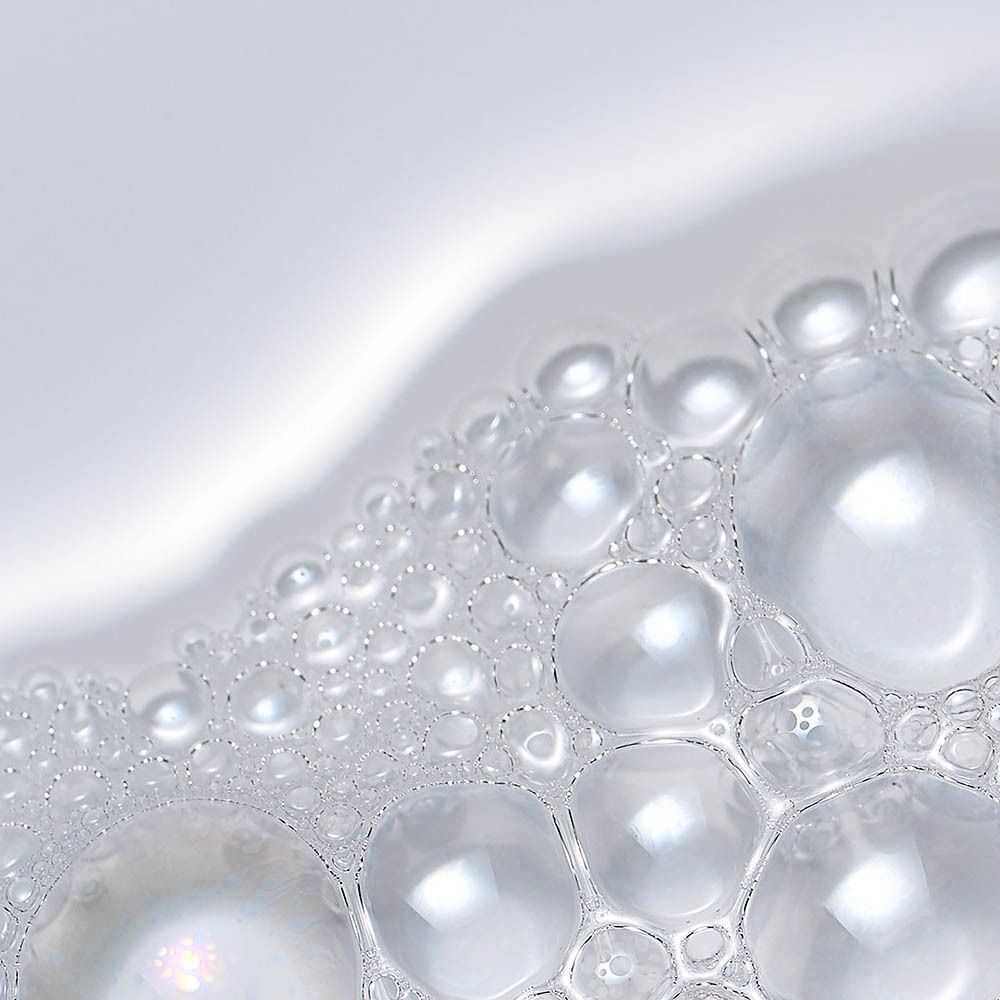 Gros plan de bulles de mousse sur fond blanc.
