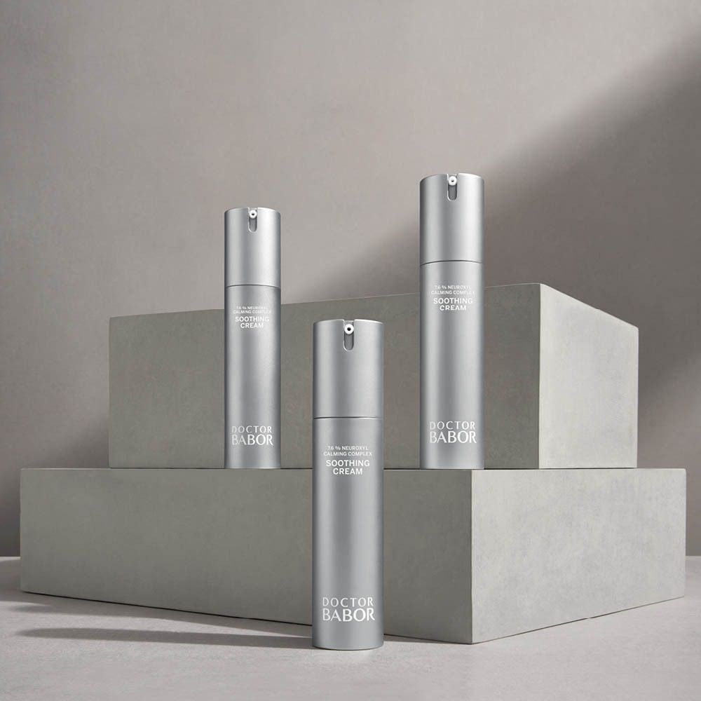 Drie zilverkleurige pompflesjes met Doctor Babor Soothing Cream op grijze blokken.
