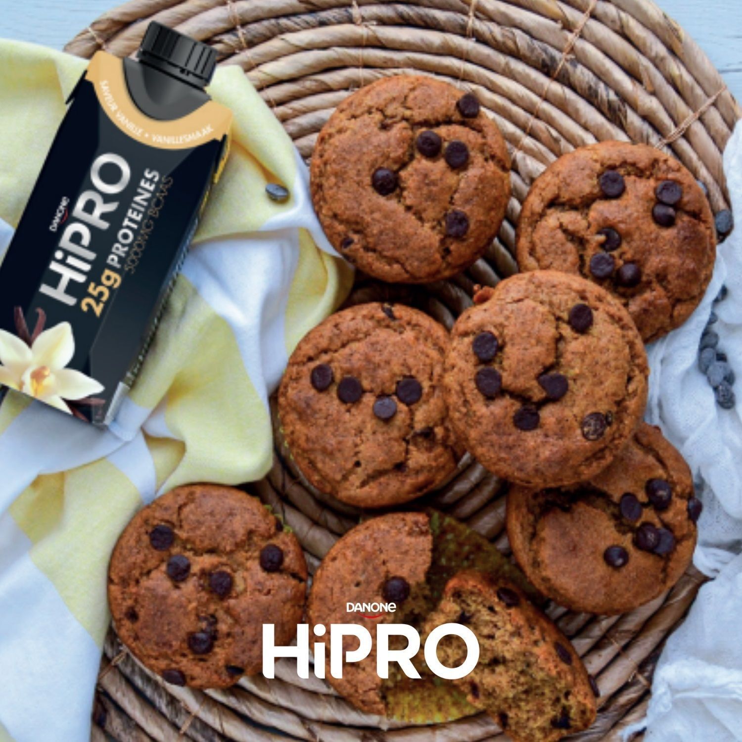Danone HiPRO Drink Vanille op een mand met chocolademuffins.