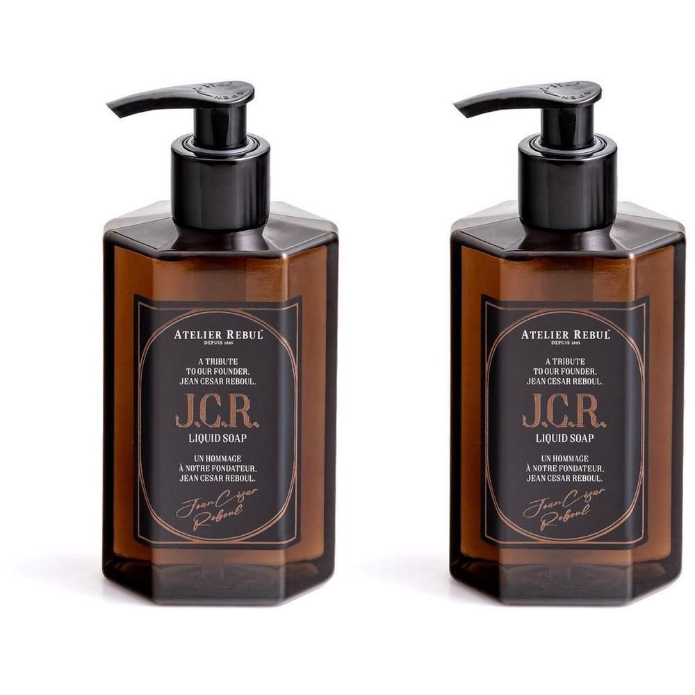 Deux flacons en verre brun avec distributeur pompe noir, contenant du savon liquide. Étiquette "J.C.R. LIQUID SOAP" et "ATELIER REBUL".