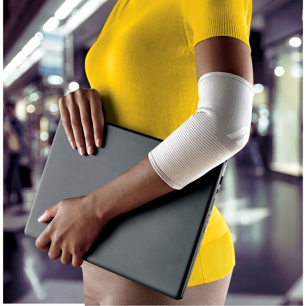 Vrouw met FUTURO Comfort Lift elleboogbandage, maat S, aan linkerarm.