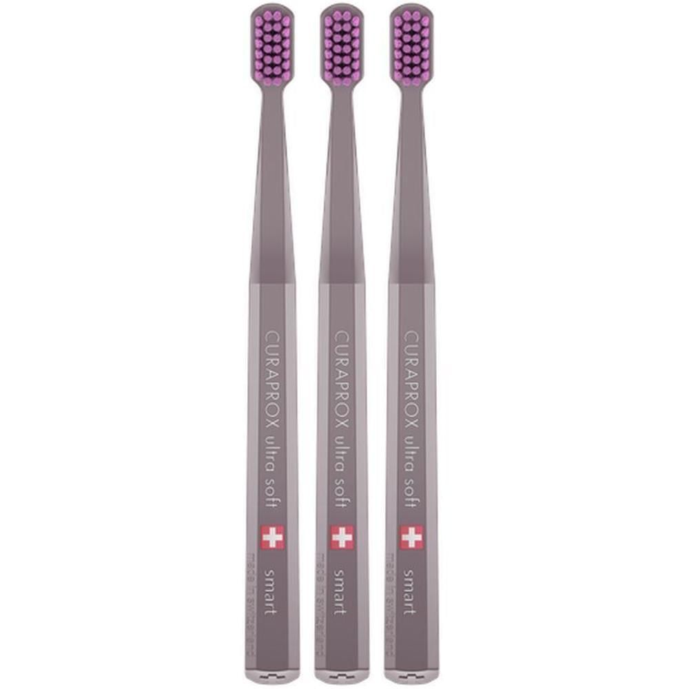 Trois brosses à dents Curaprox Smart avec poils violets et manches argentés. Les manches portent les inscriptions CURAPROX ultra soft et smart.