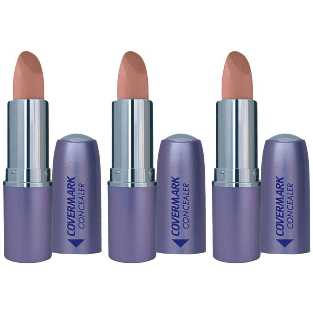 Drie Covermark Concealer sticks in paarse verpakking, met geopende dopjes.