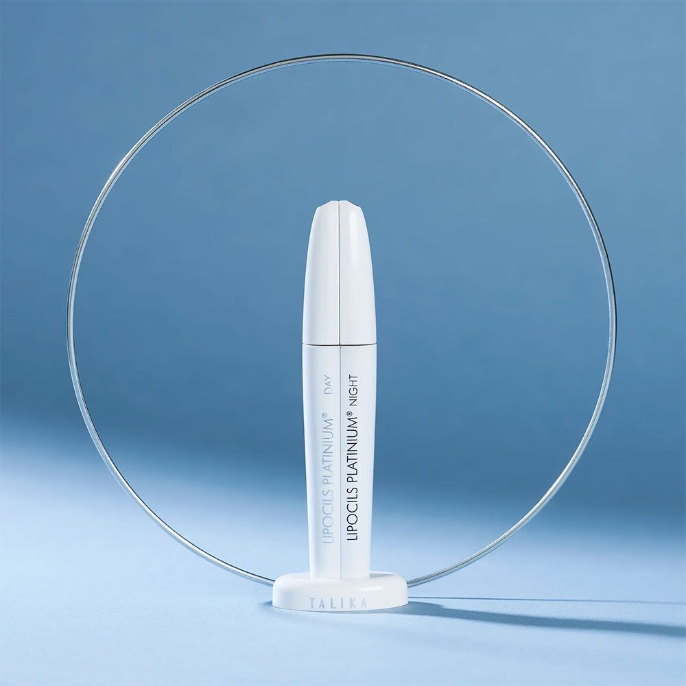 Un applicateur blanc Talika Lipocils Platinum avec accents argentés, entouré d'un anneau argenté.