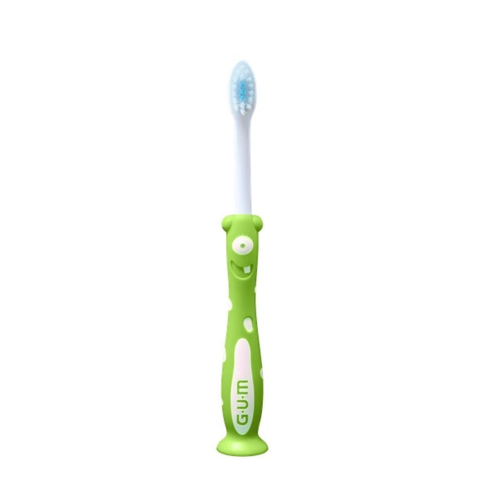 Une brosse à dents GUM Kids, souple, avec manche vert et design monstre adapté aux enfants.