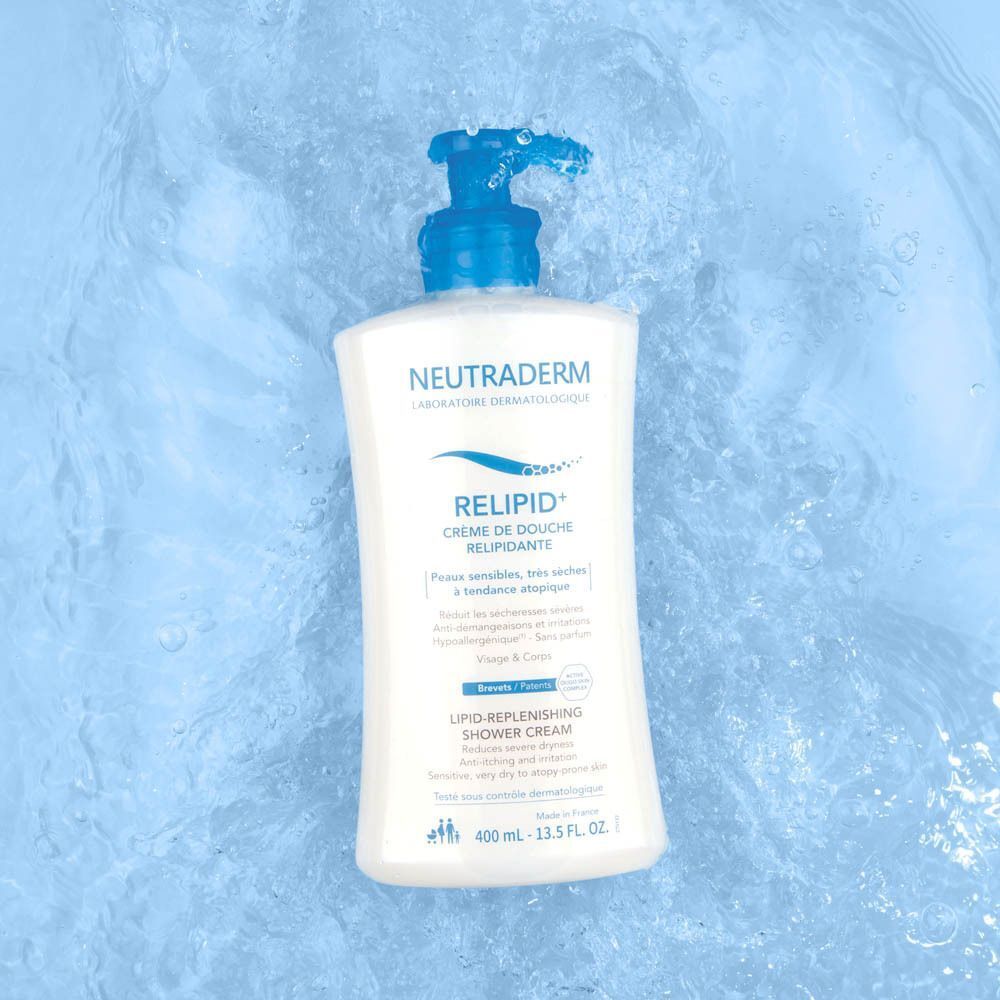 Neutraderm Relipid+ Douchecrème in een wit pompflesje met blauwe dispenser, omringd door water.
