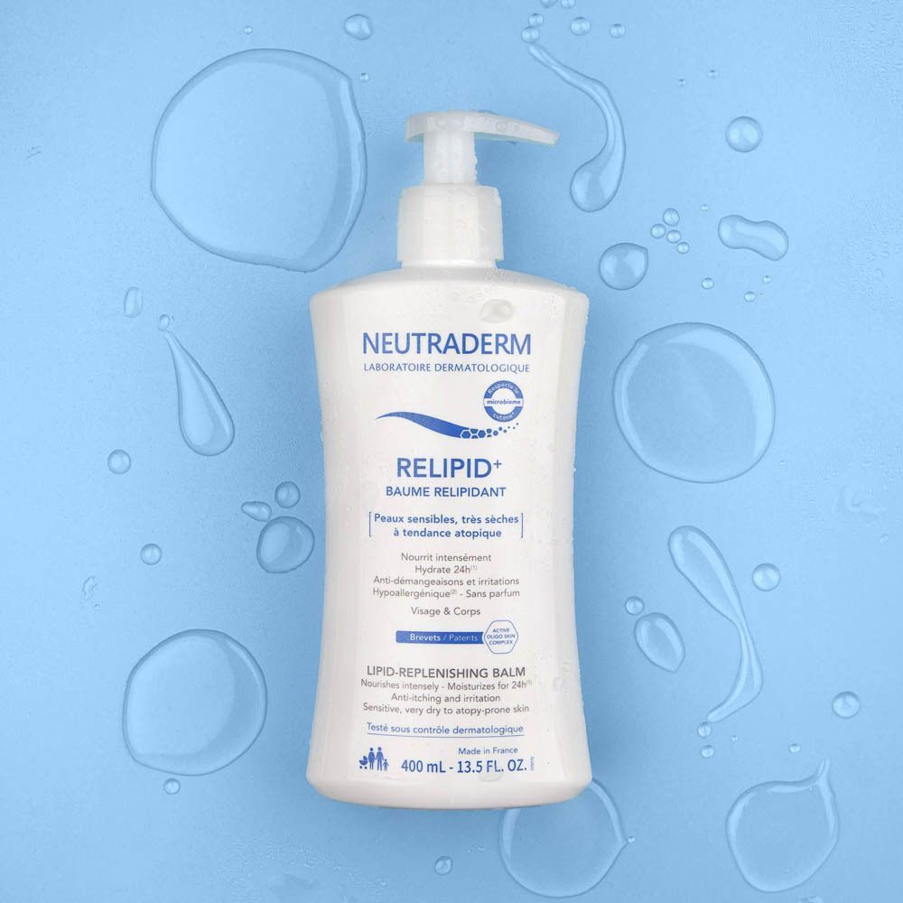 Een witte Neutraderm Relipid+ Baume pompfles met dispenser, omringd door waterdruppels op een blauwe achtergrond.