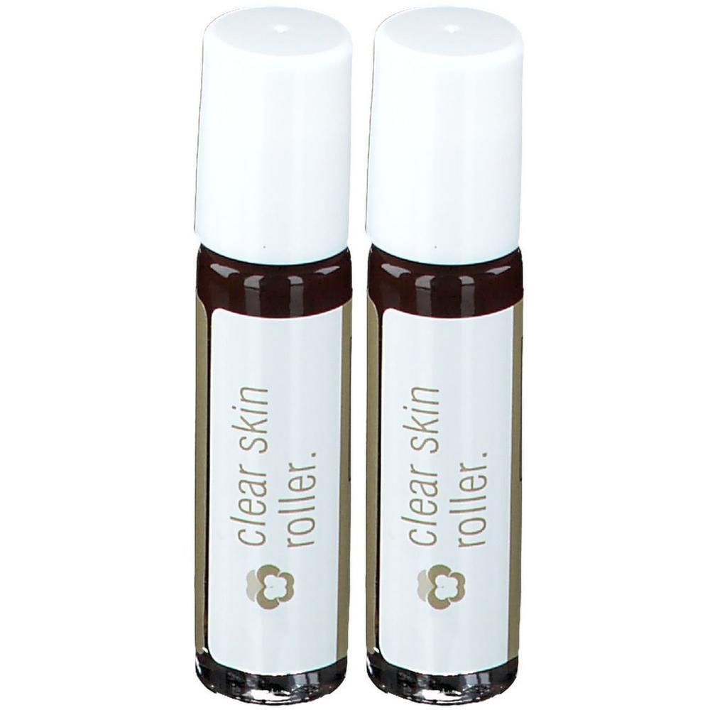 Twee glazen rollers met witte doppen en etiketten met "clear skin roller."