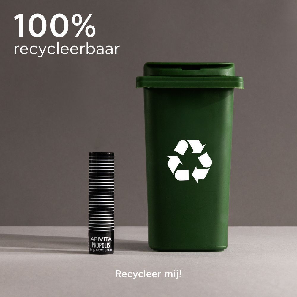 Apivita Propolis lippenbalsemstick naast een groene afvalbak. 100% recyclebaar. Recycle hem!